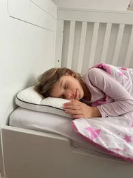 Parent photo: a young girl asleep on the Hushly Kids pillow in her bed