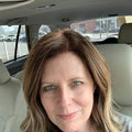 Reviewer photo: a woman with long brown hair sitting in a car