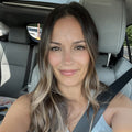 Reviewer photo: a woman with long wavy hair wearing a seat belt in a car