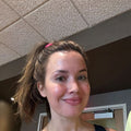 Reviewer photo: a woman with her hair in a ponytail, indoors at work