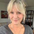 Reviewer photo: a woman with fair hair in a grey jumper, in a living room