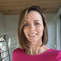 Reviewer photo: a woman with a brown bob wearing a pink top, indoors