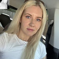 Reviewer photo: a blonde woman in a white t-shirt sitting in a vehicle