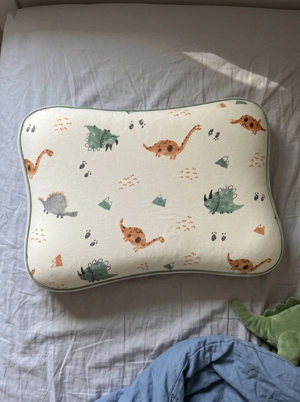 The Hushly Kids pillow in its Dino pillowcase on a child's bed