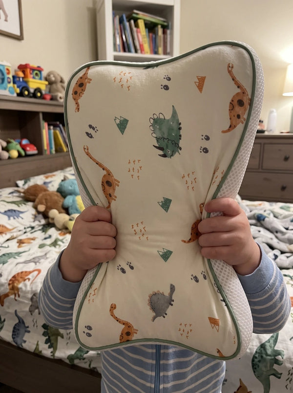 A child holding up the Hushly Kids pillow in its Dino pillowcase
