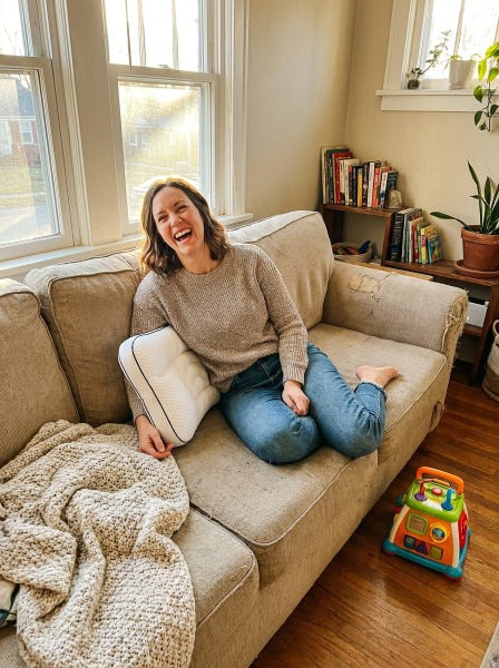 Mum laughing on the sofa with the pillow