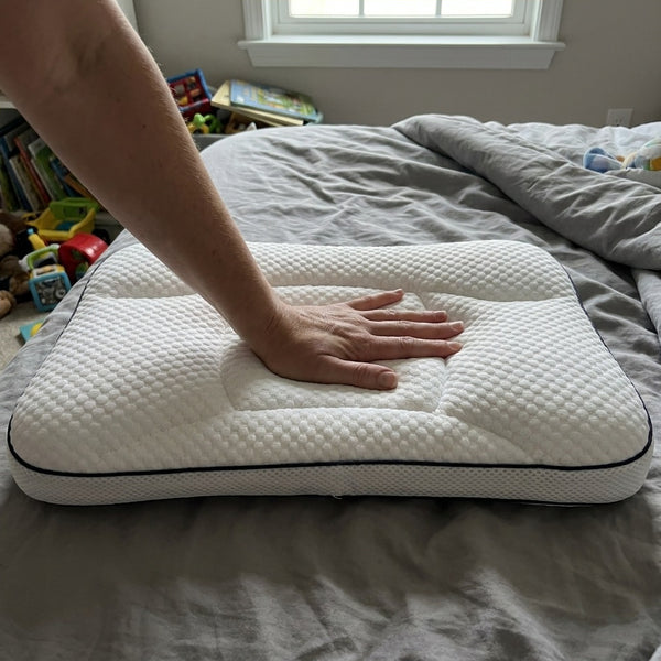 Hand pressing the pillow to test the firmness