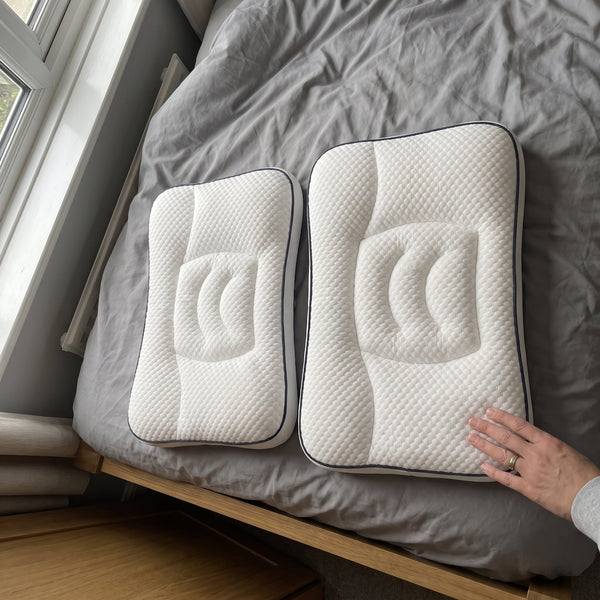 Two sizes of the pillow side by side on a bed