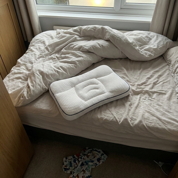 Hushly Kids pillow on an unmade bed by the window in the morning