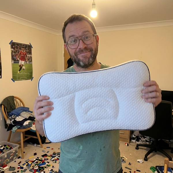 Dad holding up the Hushly Kids pillow in his son's bedroom