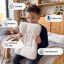 A boy holding the pillow in his bedroom, with badges: durable, resilient, odour free, gentle on skin, hypoallergenic